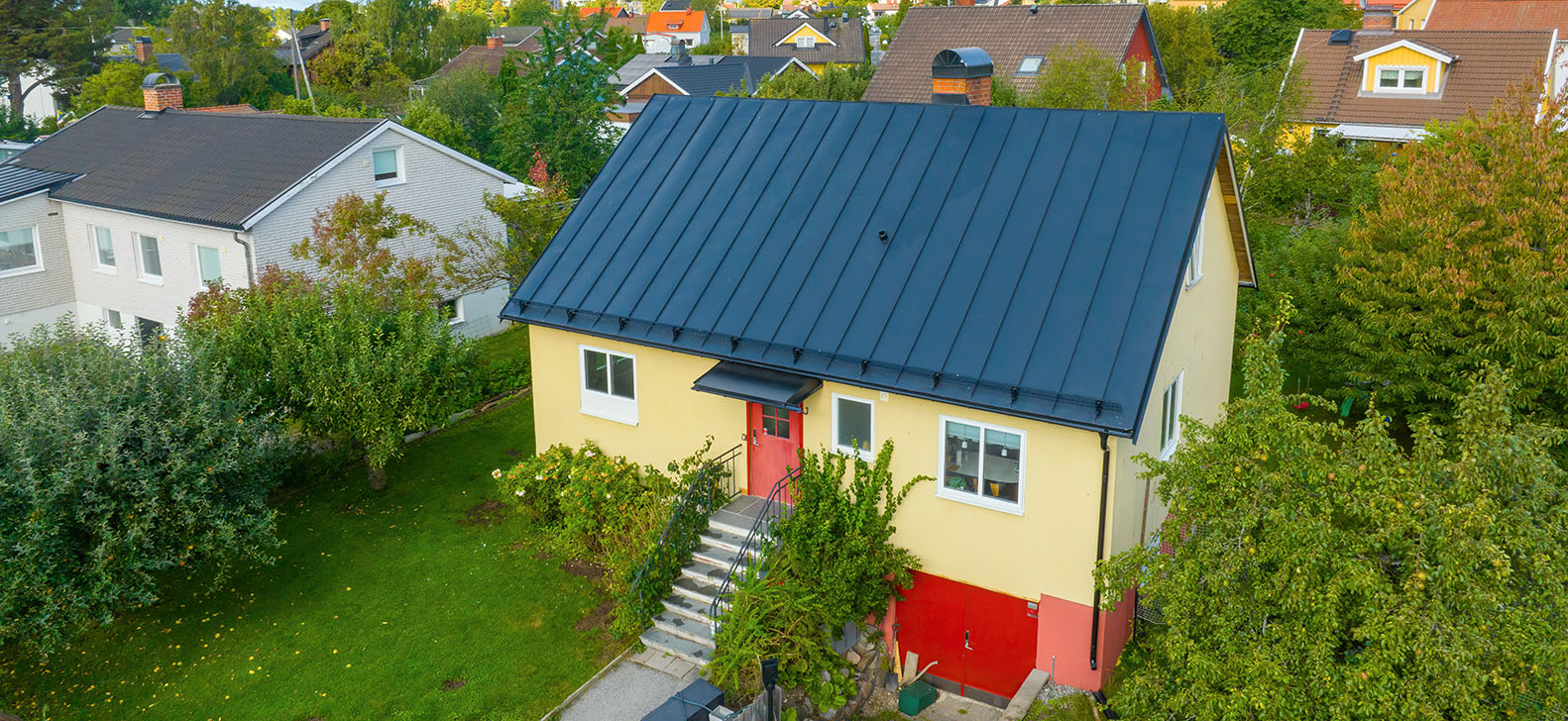 Gul villa med svart plåttak